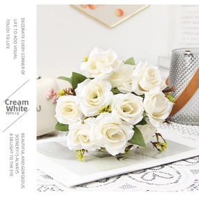 Detail of cream white silk rose bouquet with realistic green leaves for home decoration