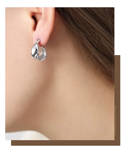 Close-up of geometric silver earrings with polished finish and modern irregular design