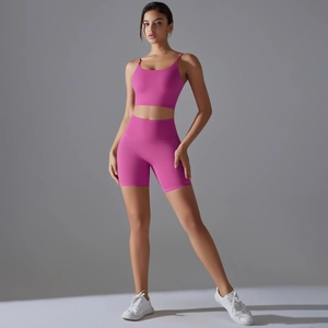 Dettaglio degli shorts fitness a vita alta rosso rosa e reggiseno sportivo con scollo a U