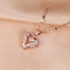 Close-up of rose gold heart pendant with cubic zirconia on silk background