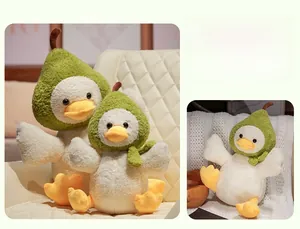 Détails de peluches canard-poire en deux tailles sur un canapé beige texturé