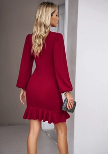 Detail of burgundy puff sleeve dress showing ruffled hem and elegant slim silhouette