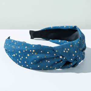Detail of dark blue denim knot headband with golden star patterns and black inner lining