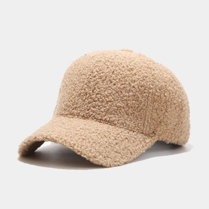 Makro-Detail der beigen Lammwoll-Textur auf einer warmen Fleece-Baseballkappe
