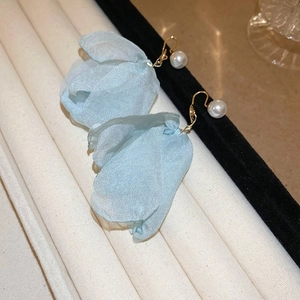 Detail of blue fabric flower earrings with white pearls and gold metal hooks