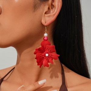 Close-up of model wearing red 3D floral earrings with white pearls and gold hooks