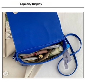 Macro shot showing internal capacity of the blue PU leather jacket bag with daily items