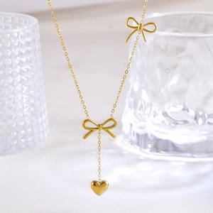 Elegant gold stainless steel necklace with bow accents and a delicate heart pendant