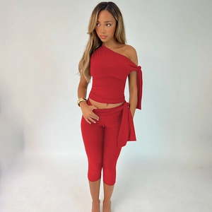 Detail of red one-shoulder crop top and matching slim-fit leggings set on model