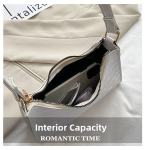 Detailed interior of a white croc-effect shoulder bag showing daily essentials and space