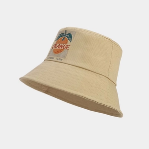 Gros plan sur un bob kaki avec broderie d'orange et inscription PASTORAL TASTE