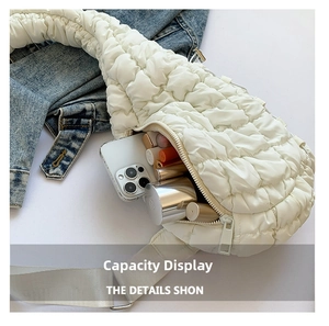 Détail montrant la grande capacité de ce sac à bandoulière matelassé blanc cassé avec objets