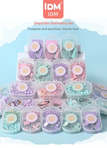 Close-up of pastel macaron-colored paper clips and binder clips in clear storage boxes