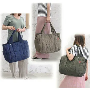 Quilted nylon diaper tote bag with multiple pockets shown in three colors and on a model