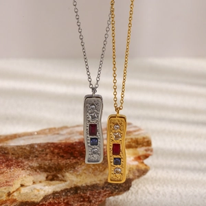 Detailed close-up of 18K gold and silver rectangular pendants with colorful zircons