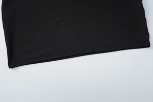 Detailed macro view showing the high-quality stitching on the black knit dress hemline