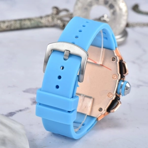 Detail of blue silicone strap with silver buckle and rose gold case back on luxury watch