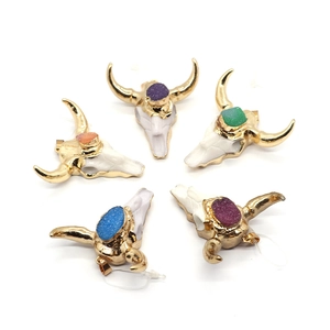 Resin bull head pendant with colorful crystals and gold-plated horns on white background