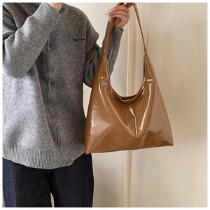 Dettaglio della texture in finta pelle marrone di una borsa a tracolla hobo da donna