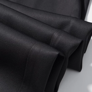 Detaillierte Makroaufnahme von schwarzem Twill-Stoff mit Fokus auf Textur und Faltenwurf
