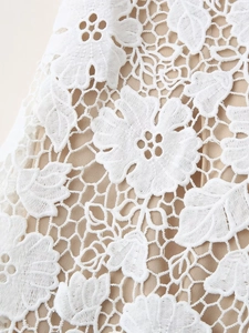 Gros plan détaillé sur la dentelle florale blanche avec une doublure intérieure beige
