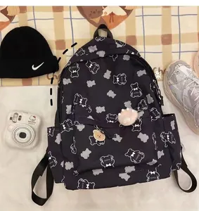 Detail of waterproof nylon backpack featuring cute bear prints and a plush charm