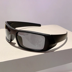 Detail of futuristic cycling sunglasses with black frame and dark grey lenses on white stand