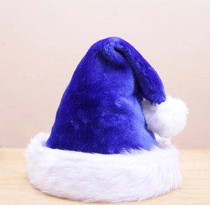 Detailed close-up of a blue velvet Christmas hat with soft white faux fur trim and pompom