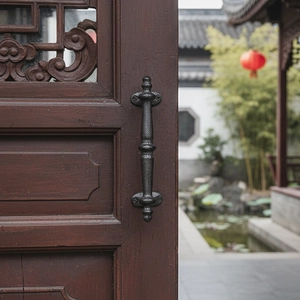 Vintage black iron cabinet handle with hammered texture on a classic wooden door