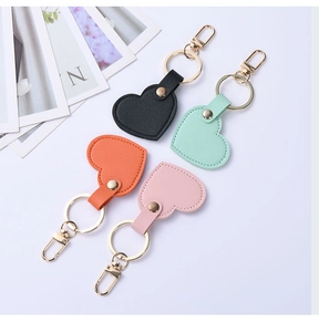 Detail of heart-shaped leather keychains in various colors with gold metal hardware