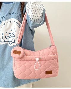 Détail du sac à bandoulière rose matelassé avec motif cœur et petit porte-monnaie