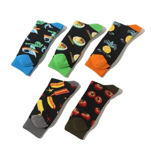 Flat lay of five mid-calf cotton socks with alien, ramen, and fruit cartoon patterns