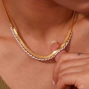 Close-up of a gold-plated herringbone necklace featuring shimmering micro-pave cubic zirconia
