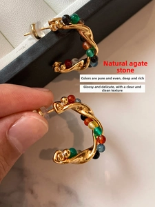 Detailed close-up of golden hoop earrings featuring multi-color natural agate stone beads