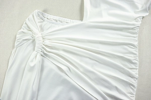 Detailed close-up of white ruched fabric with intricate asymmetrical pleats and texture