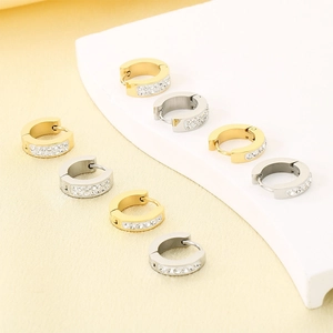 Detail of gold and silver huggie earrings with sparkling cubic zirconia on soft velvet