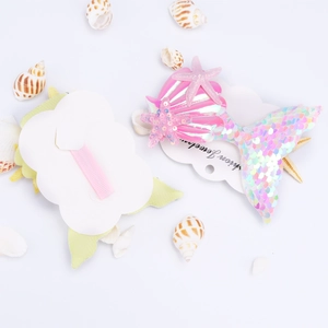 Girl's mermaid tail hair clip set with pink sequins and starfish on a display card