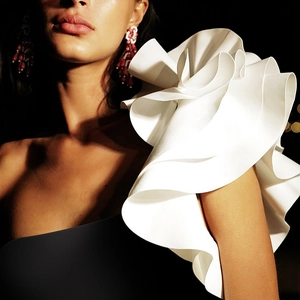 Detailed view of elegant white multi-layered ruffle shoulder design on a swimsuit