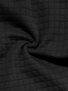 Close-up of black waffle knit fabric showing the detailed texture of the men's summer set