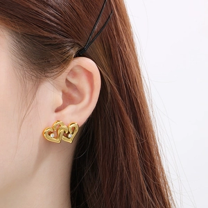 Elegant 18K gold plated interlocking heart stud earrings worn by model on white background