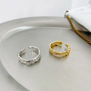 Close-up of irregular lava texture on gold and silver S925 sterling silver rings