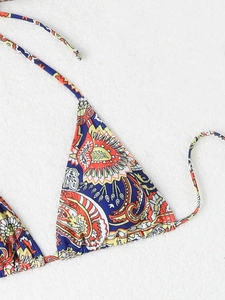 Detailed flat lay of triangle bikini top with vibrant bohemian ethnic pattern and tie strings