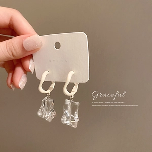 Minimalist irregular acrylic drop earrings with geometric silver metal buckle held by hand