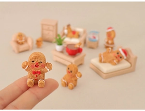 Macro shot of miniature gingerbread man on finger for dollhouse scene decoration