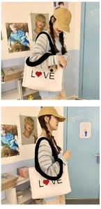Detail of white plush love tote bag with red heart embroidery and black shoulder strap