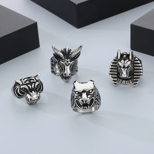 Detailed close-up of retro silver wolf, tiger, and goat head stainless steel rings