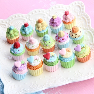 Miniature resin cupcake charms with colorful berry accents on white decorative plate