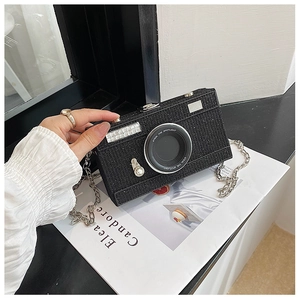 Macro detail of camera-shaped evening clutch bag with black glitter and silver chain