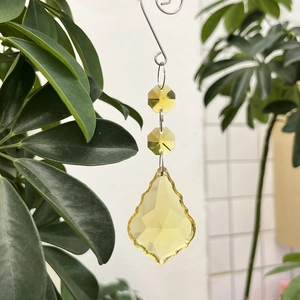 Detail of yellow faceted crystal maple leaf pendant catching sunlight outdoors