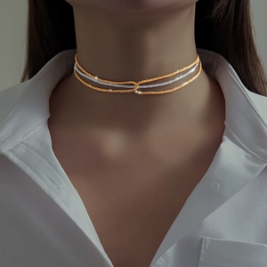 Detail of elegant gold and silver triple-layered choker chains on model neckline